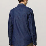 Back view of blu canary classic shirt on model wearing green pants, against a white background.