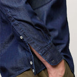 Side closeup view of blu canary classic shirt on model wearing green pants, against a white background.