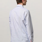 Back view of azzurro canary classic shirt on model wearing green pants, against a white background.