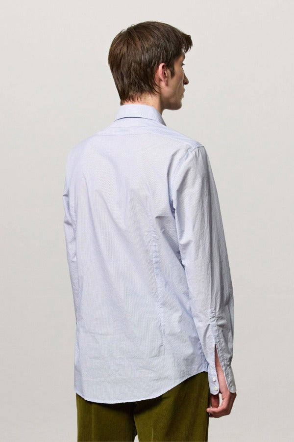Back view of azzurro canary classic shirt on model wearing green pants, against a white background.