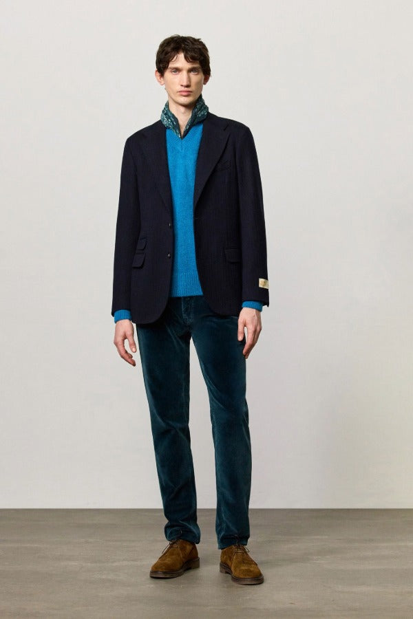 Front view of blue catch2 jacket on model wearing blue sweater and pants with boots, against a white background.