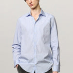 Front view of azzurro genova classic shirt on model  wearing grey pants, against a white background.