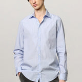 Front view of azzurro genova classic shirt on model  wearing grey pants, against a white background.