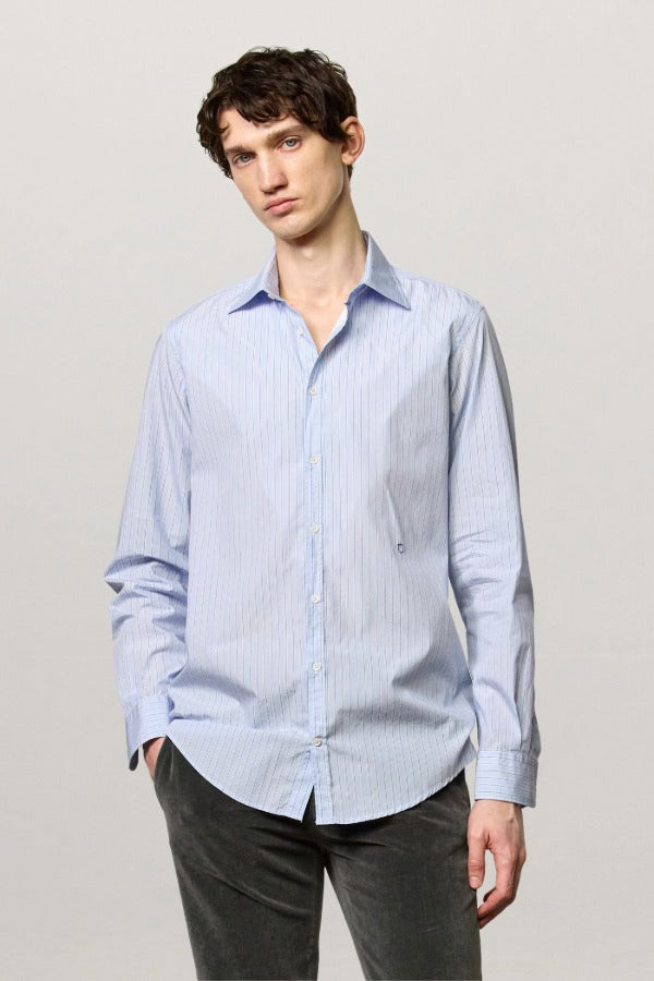 Front view of azzurro genova classic shirt on model  wearing grey pants, against a white background.