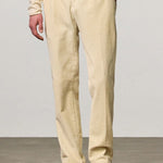 Front view of milk ionio2 trouser on model wearing milk top and brown boots, against a white background.