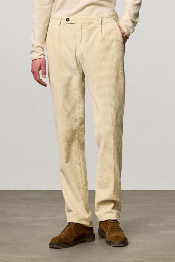 Front view of milk ionio2 trouser on model wearing milk top and brown boots, against a white background.
