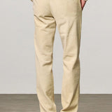 Back view of milk ionio2 trouser on model wearing milk top and brown boots, against a white background.