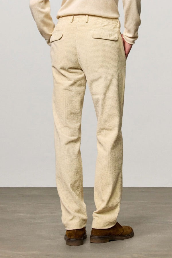 Back view of milk ionio2 trouser on model wearing milk top and brown boots, against a white background.