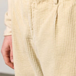 Front closeup view of milk ionio2 trouser on model wearing milk top, against a white background.
