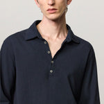 Front closeup view of dark blue ischia ls polo shirt on model, against a white background.