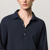 Front closeup view of dark blue ischia ls polo shirt on model, against a white background.