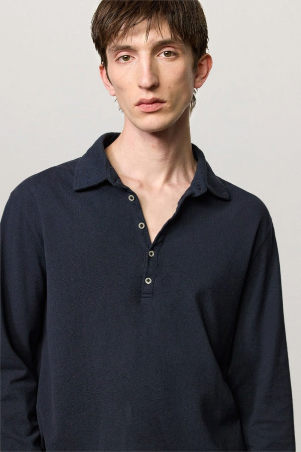 Front closeup view of dark blue ischia ls polo shirt on model, against a white background.