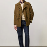 Front view of rusk lucio peacoat on model wearing blue pants and a milk top with boots, against a white background.