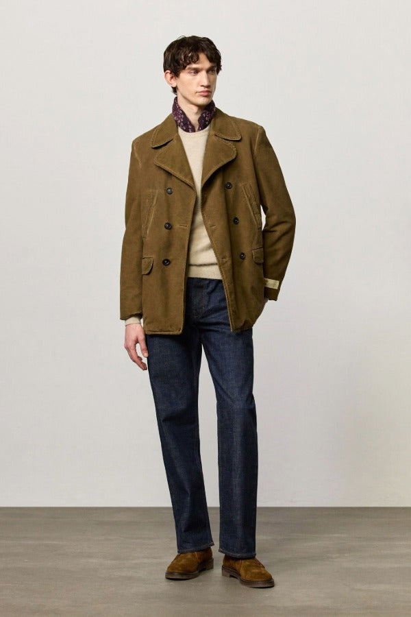 Front view of rusk lucio peacoat on model wearing blue pants and a milk top with boots, against a white background.