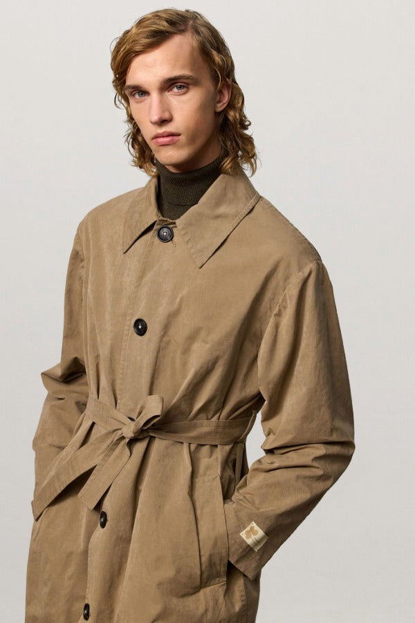 Front closeup view of beige mustang trench on model, against a white background.