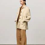 Front view of milk rouen jacket on model wearing tan pants, top and boots, against a white background.