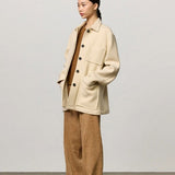 Front view of milk rouen jacket on model wearing tan pants, top and boots, against a white background.