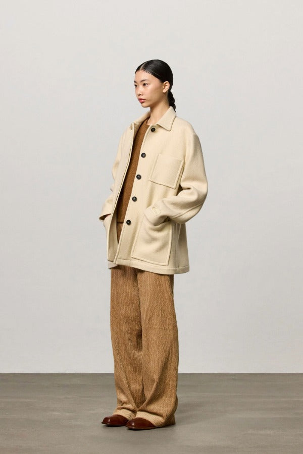 Front view of milk rouen jacket on model wearing tan pants, top and boots, against a white background.