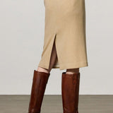 Back view of naturale rugaida skirt on model wearing ls shirt and boots, against a white background.