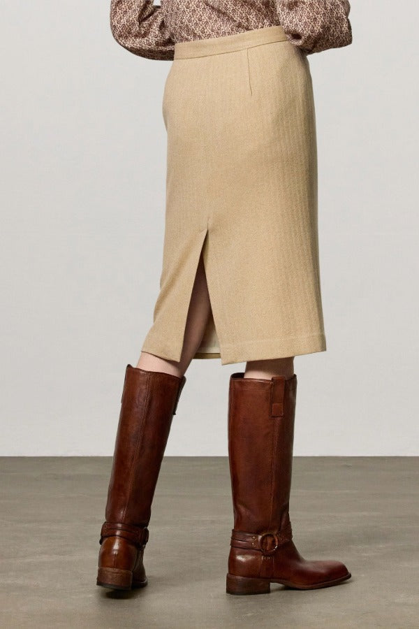 Back view of naturale rugaida skirt on model wearing ls shirt and boots, against a white background.
