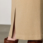 Side closeup view of naturale rugaida skirt on model wearing boots, against a white background.