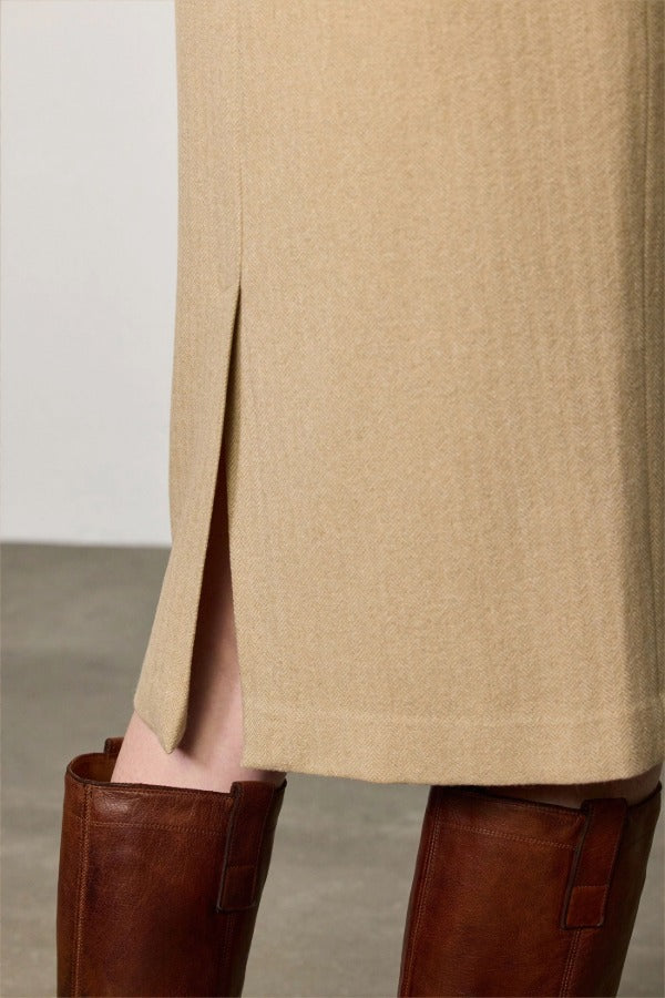 Side closeup view of naturale rugaida skirt on model wearing boots, against a white background.