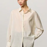 Front view of milk selma classic shirt on model wearing green pants, against a white background.