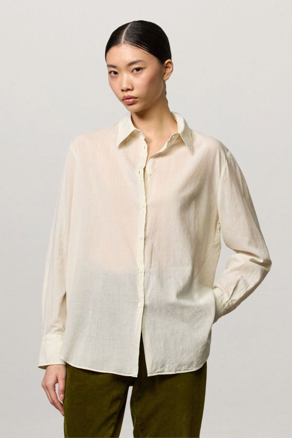 Front view of milk selma classic shirt on model wearing green pants, against a white background.