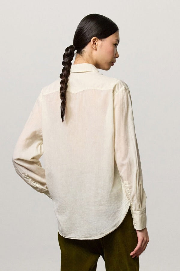 Back view of milk selma classic shirt on model wearing green pants, against a white background.