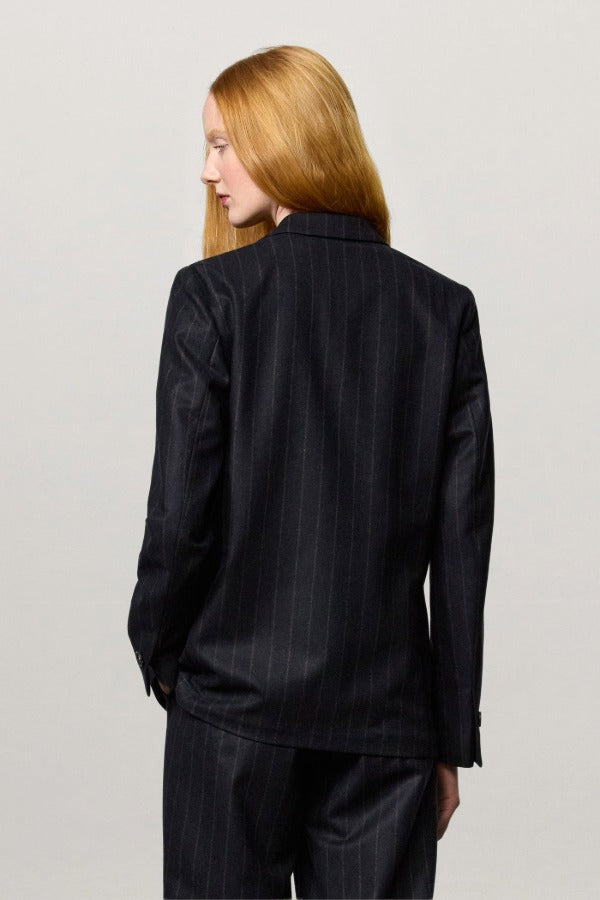 Back view of blu stromboli blazer on model wearing blu pants, against a white background.