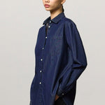 Front view of blue uma classic shirt on model wearing black pants, against a white background.