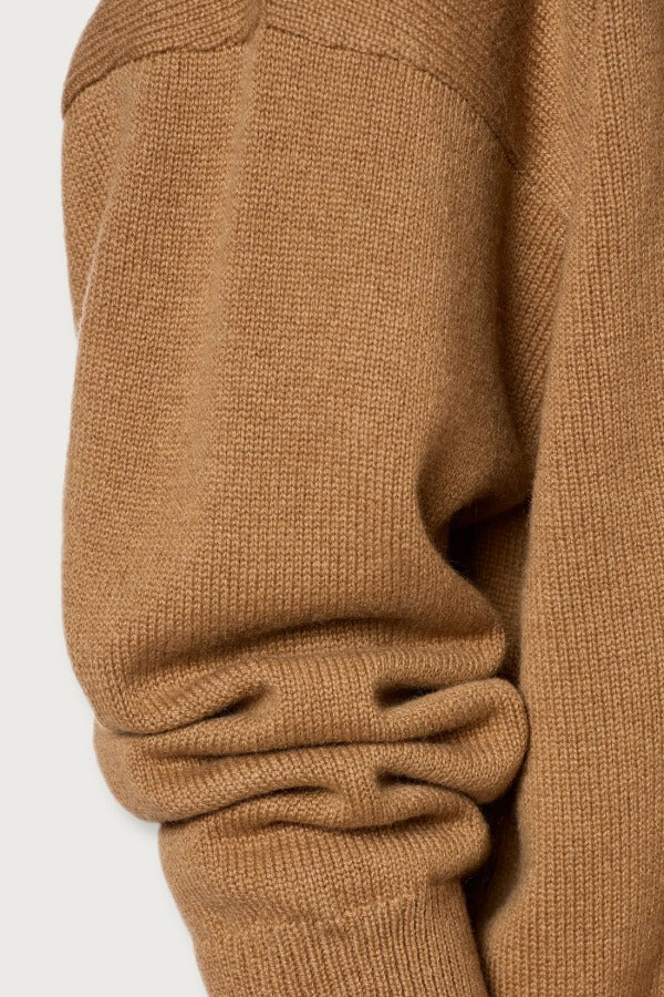 Side closeup view of cannella valentina v-neck sweater on white background, with no model shown.