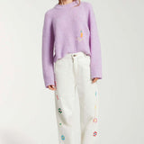 Front view of white straight leg jean on model wearing purple sweater and white sneakers, against a white background.