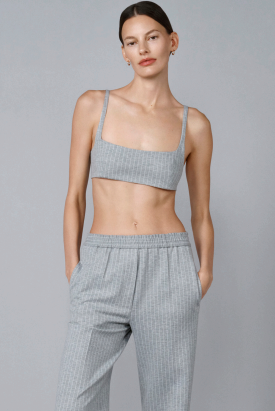 Front view of grey striped bralette in jersey on model wearing grey striped pants, against a grey background