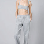 Front view of grey stripes jersey jogger pant on model wearing grey bra, against a grey background.