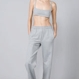 Front view of grey stripes jersey jogger pant on model wearing grey bra, against a grey background.
