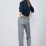 Back view of navy blue herringbone paris pant on model wearing navy top and sneakers, against a white background.