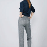 Back view of navy blue herringbone paris pant on model wearing navy top and sneakers, against a white background.