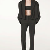 Front view of black the jacket on model wearing black pants and heels, against a white background.