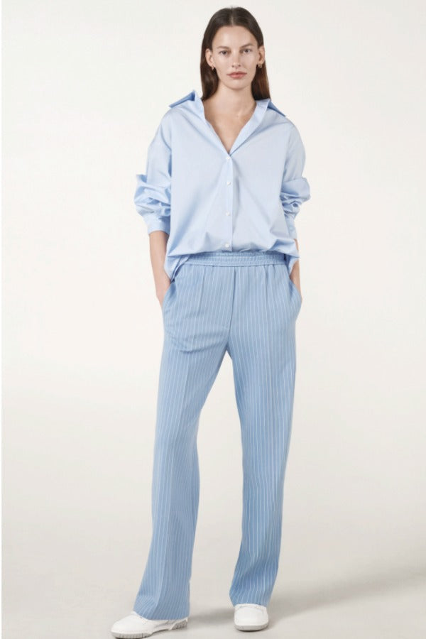 Alternate front view of blue the shirt on model wearing blue pinstriped pants, against a white background.
