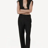 Front view of black unisex pant on model wearing open black sweater, against a white background.