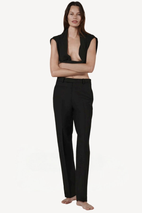 Front view of black unisex pant on model wearing open black sweater, against a white background.