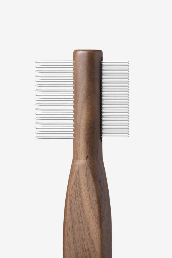 Side view of combing tool form Pansage grooming kit on white background, with no model shown.