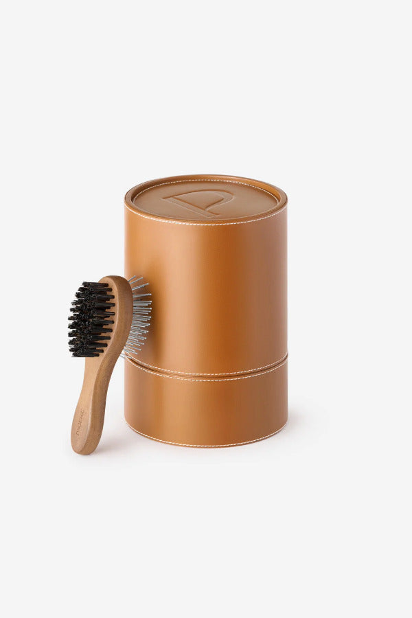 Side view of brush tool Pansage grooming kit against the box on white background.
