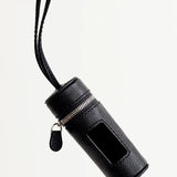 Front view of black pouchette dog bag holder on white background, with no model shown.