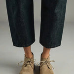 Front view of pair of sand antoine desert boots on model wearing cropped jeans, against a white background.