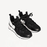 Front slanted view of black/white calf/canvas trek comet sneakers on white background, with no model shown.