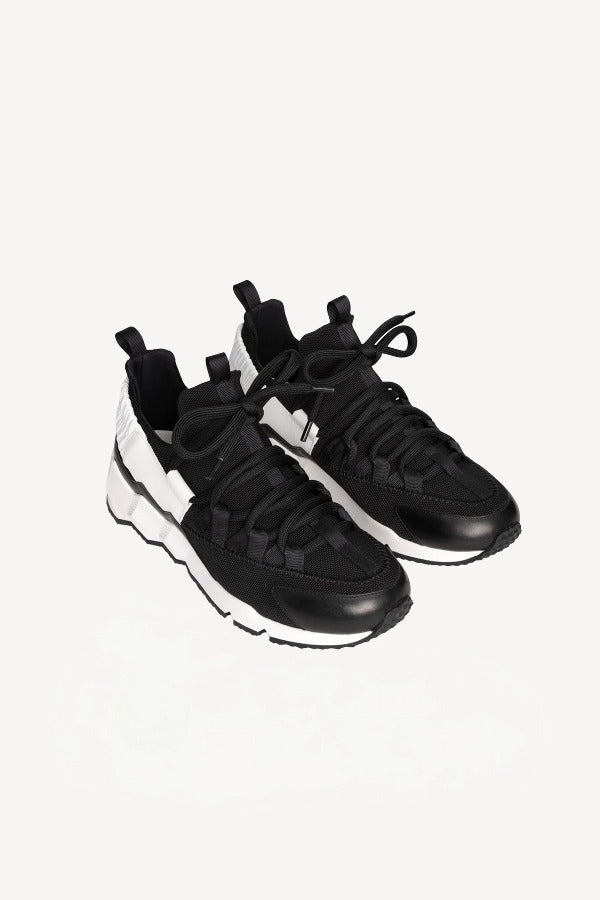 Front slanted view of black/white calf/canvas trek comet sneakers on white background, with no model shown.