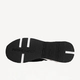 Sole view of black/white calf/canvas trek comet sneaker on white background, with no model shown.