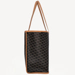 Side view of black/tan canvas cube and calf cab tote on white background, with no model shown.